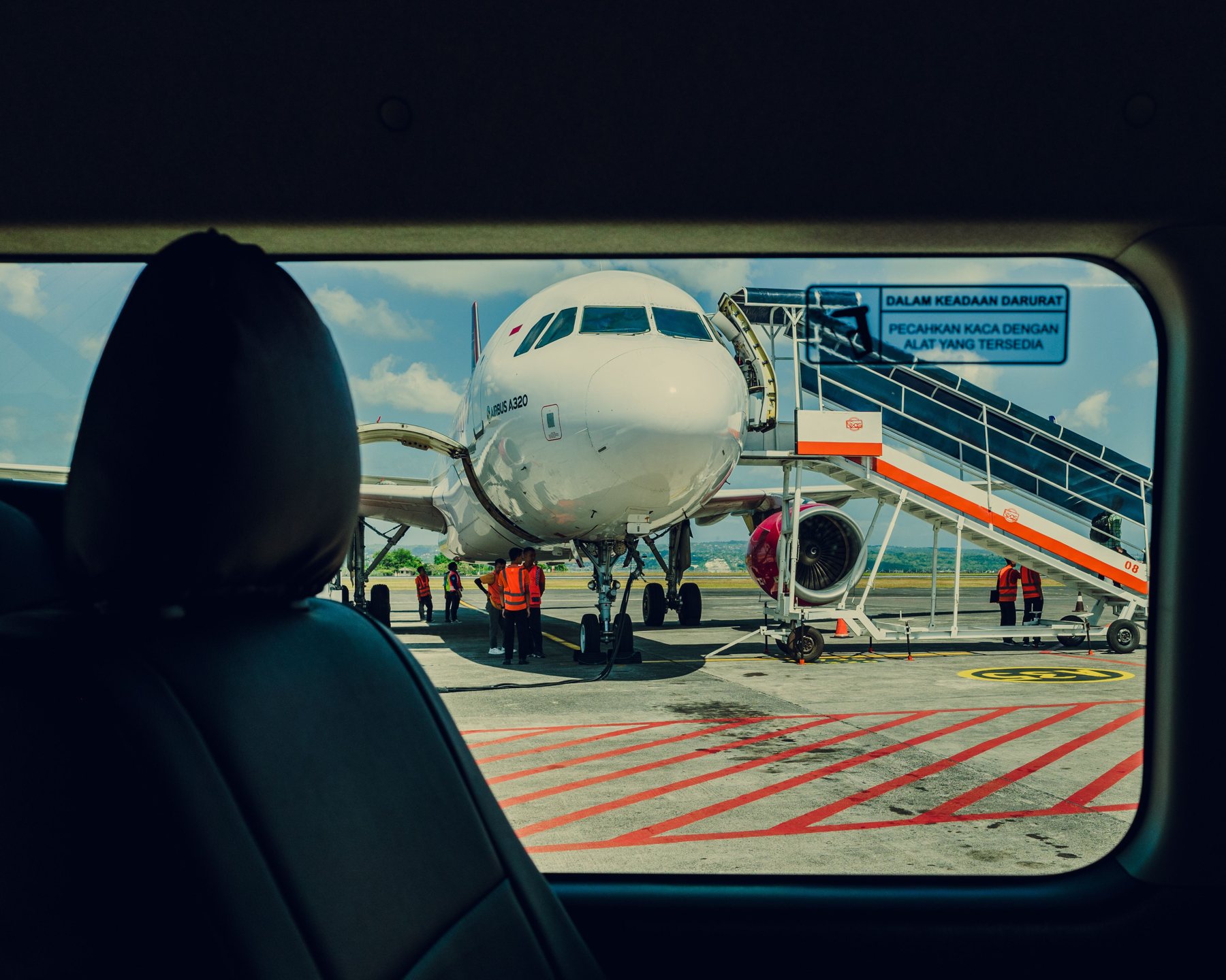 A plane waiting on the apron, seen through a shuttle window
